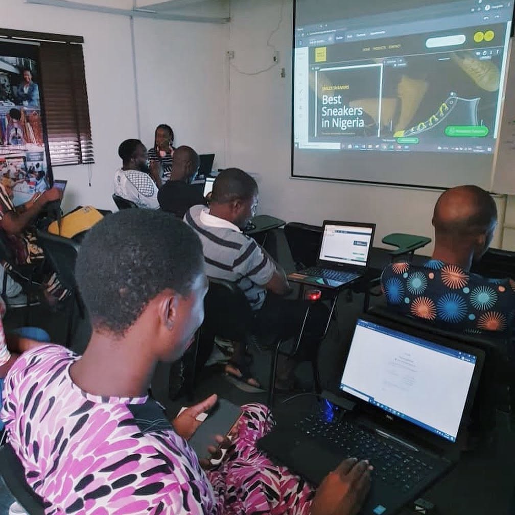 Academy participants working on laptops during a web design class